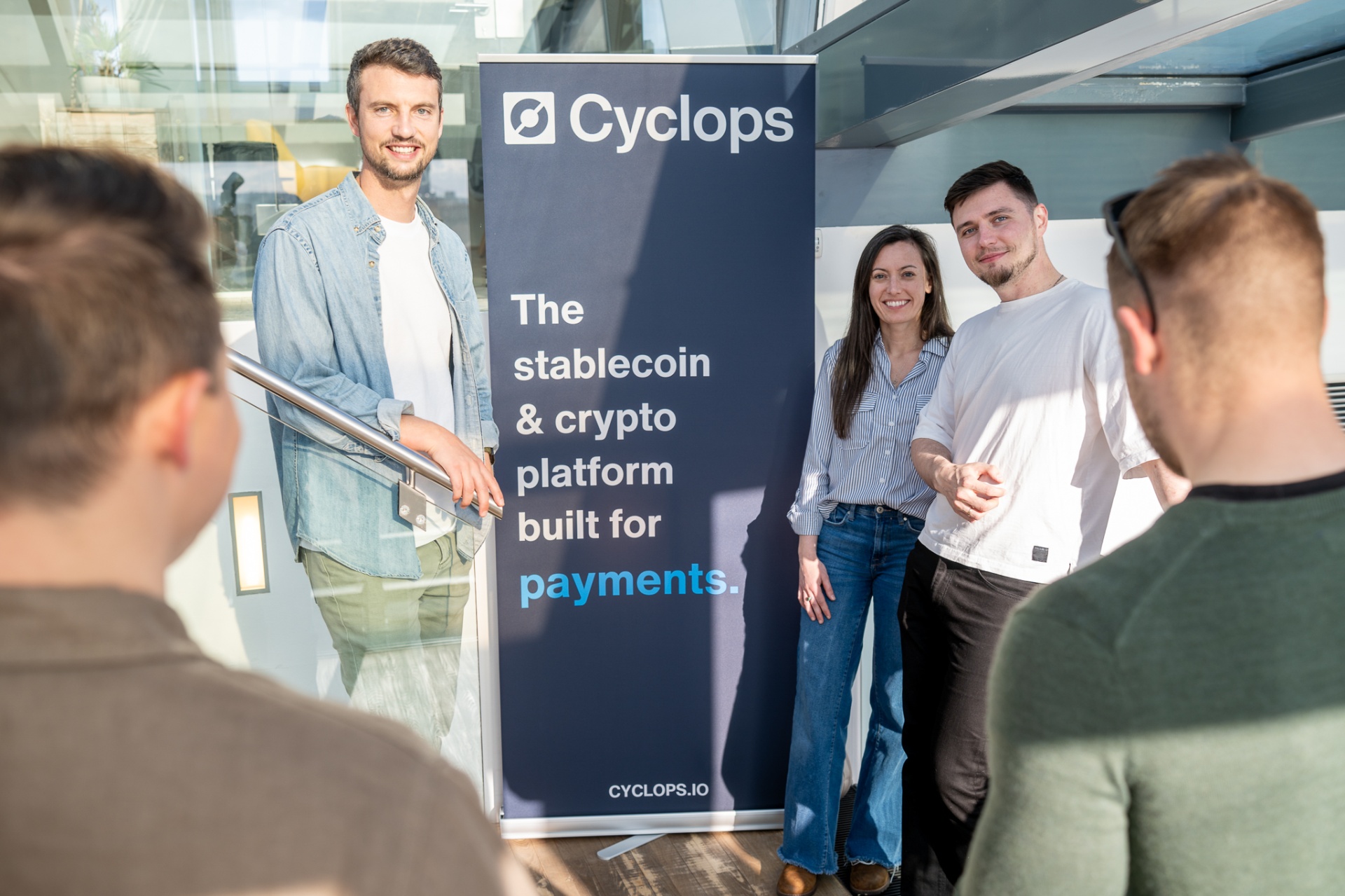 Cyclops team beside the stablecoin and crypto platform banner